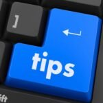 Gros plan sur un clavier avec une touche bleue "Tips", illustrant des conseils et astuces pour améliorer la performance et le référencement d'un site internet.