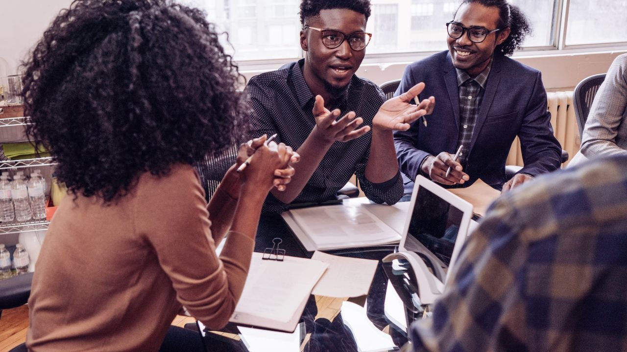 Formation IA et recrutement de talents en Guadeloupe — incubateurs et hackathons Trois professionnels lors d’un bootcamp IA en Guadeloupe — session innovation et recrutement de talents locaux